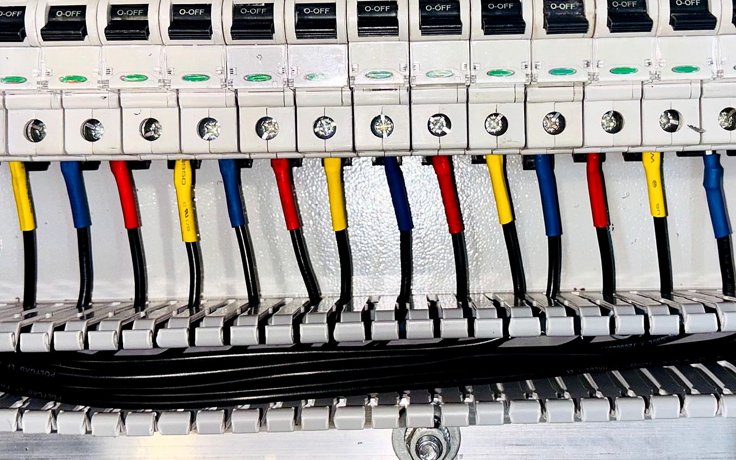 Close-up of a colourful, freshly wired switchboard with circuit breakers